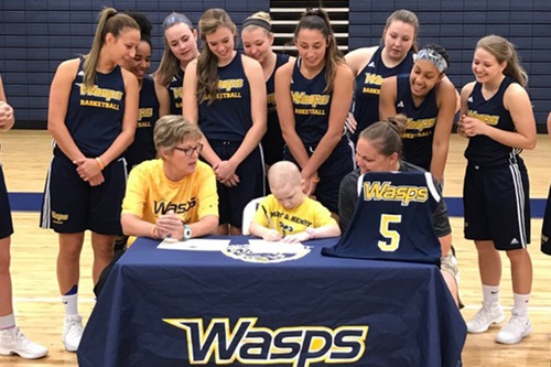 Six-year old Ellee Large signs a letter to join the E&H Women's Basketball team.